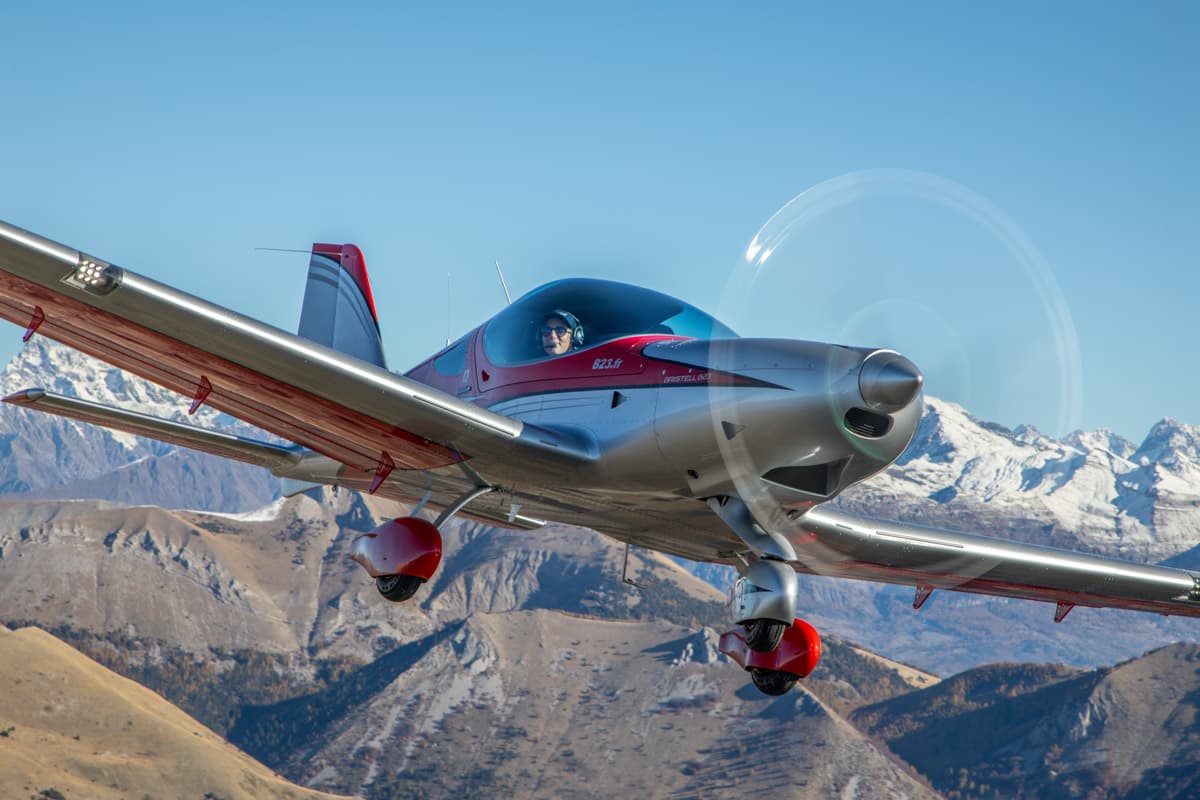 Bristell B23 low pass with the sun behind the mountains