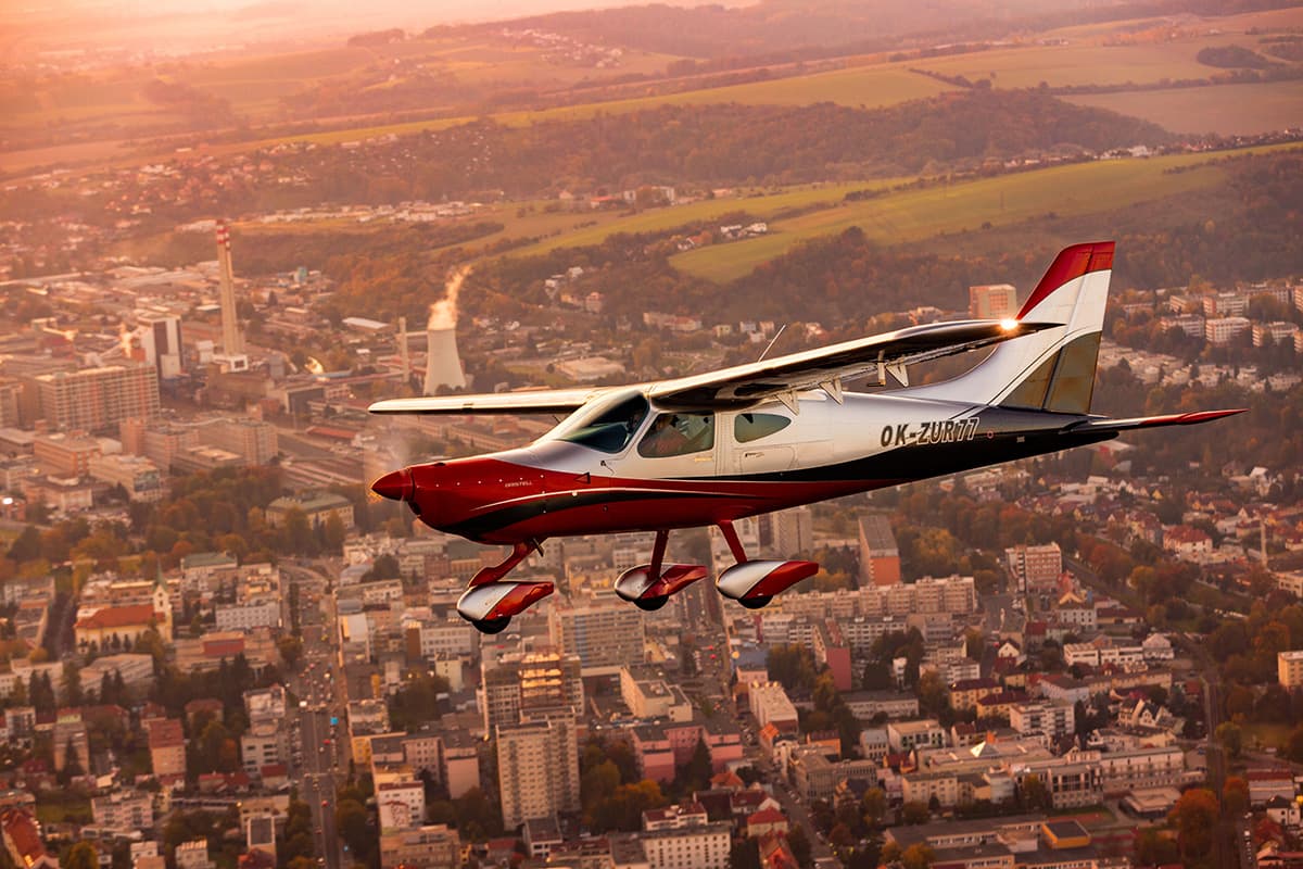 Bristell B8 banking over a town at golden hour