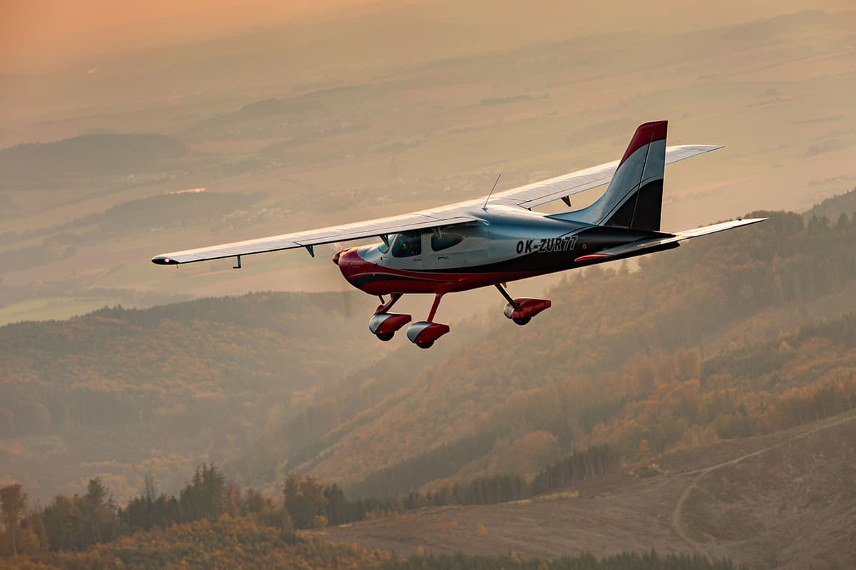 Bristell B8 in flight over autumn hills