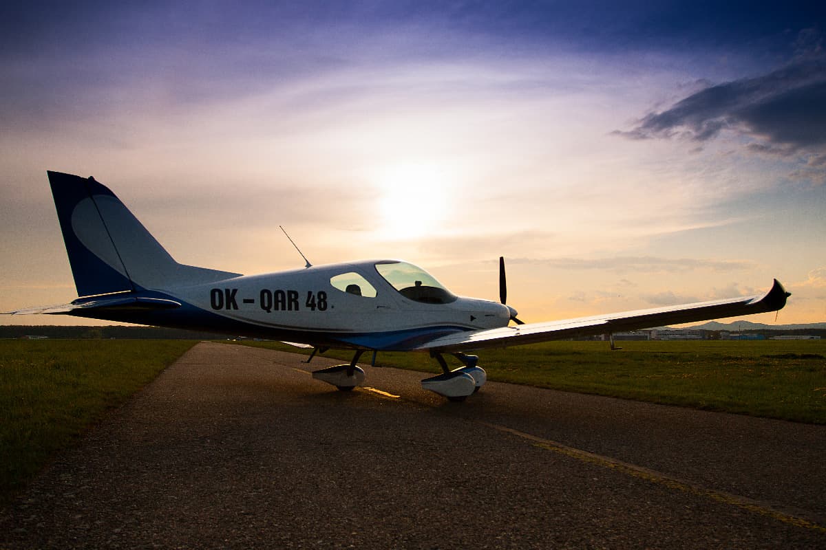 Blue and white Bristell Classic on the runway at sunset