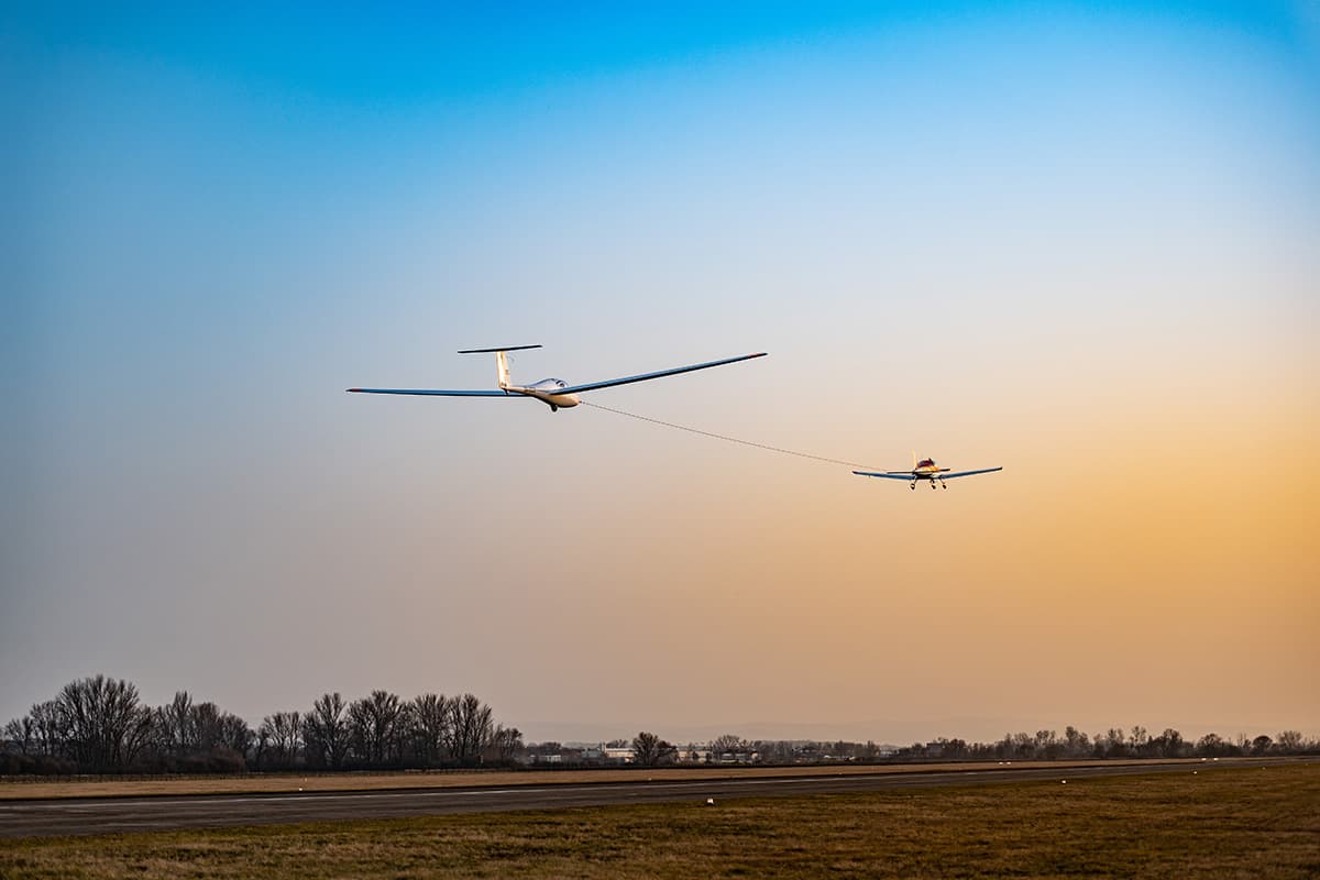 Bristell Classic towing a glider aloft at sunset