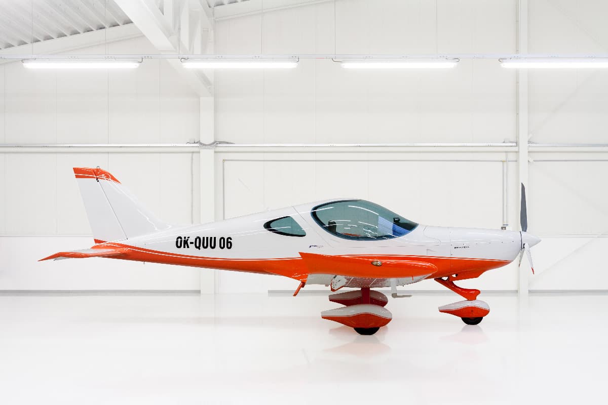 Orange and white Bristell Classic in the hangar