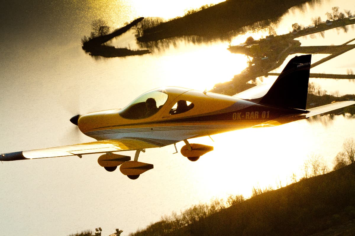 Yellow Bristell Classic over water at golden hour