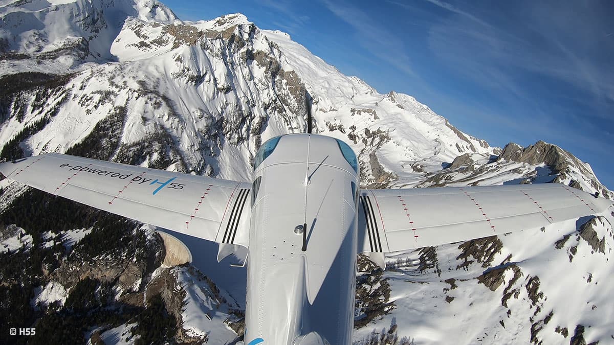 Over-the-wing view of the Bristell Energic above snowy peaks