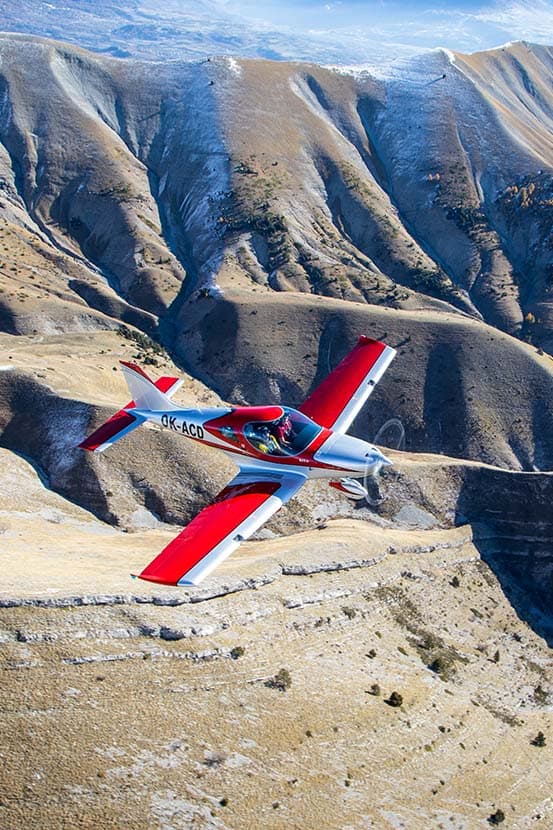 Bristell B23 Mosaic flying over a mountain ridge