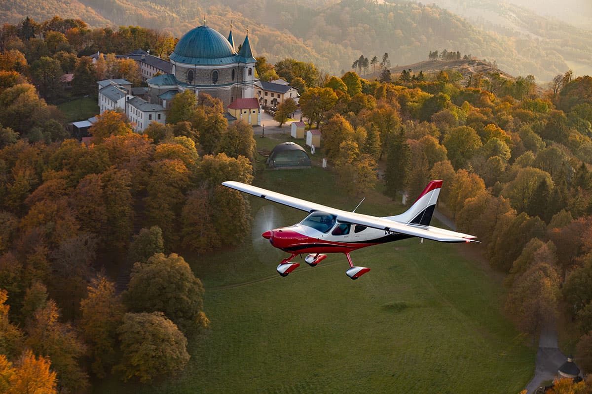 Bristell B8 cantilever high wing in flight over an autumn landscape